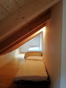 een kleine kamer met 2 bedden op een zolder bij Antico Maso in Lavarone