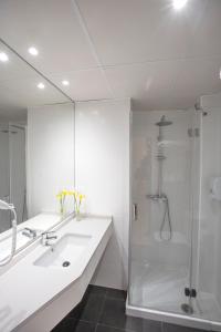 a white bathroom with a shower and a sink at Hotel Ciudad De Calahorra in Calahorra