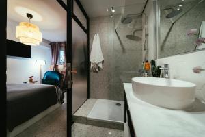 a bathroom with a tub and a sink and a bed at EM Kastelo Zadar in Zadar