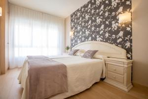 a bedroom with a bed with a black and white floral wall at Hotel Ciudad De Calahorra in Calahorra