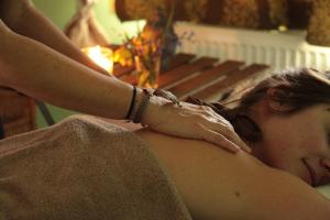 a woman getting a massage in front of a fireplace at Ô Saveur de l’Instant in Saint-Usuge