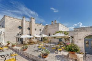 an outdoor patio with tables and chairs and umbrellas at Masseria San Domenico in Savelletri di Fasano