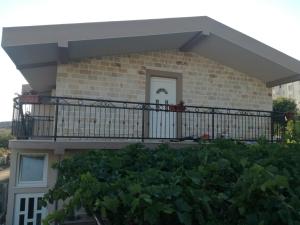 a house with a balcony with plants in front of it at Apart dom Janković in Sutomore