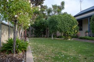 a yard with trees and a fence at Haven Cottage Kangaroo Island in Kingscote