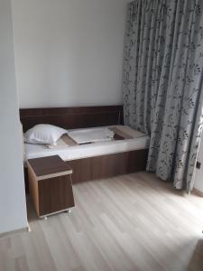 een kleine slaapkamer met een bed en een houten vloer bij La Babusca in 2 Mai
