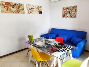 a dining room with a blue couch and a table with chairs at Bed & Smile in Valeggio sul Mincio