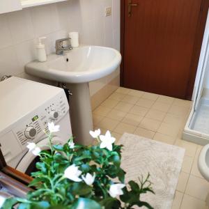 a bathroom with a sink and a toilet and a plant at Bed & Smile in Valeggio sul Mincio