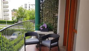 a balcony with two chairs and a table with a plant at Casa Excalibur in Pisa