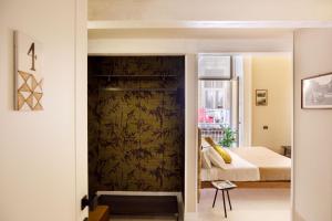ein Schlafzimmer mit einem Bett und einer Wand in der Unterkunft MelRose Napoli in Neapel