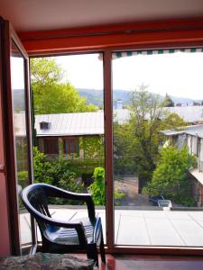 una silla sentada frente a una ventana en Green Stairs Guest house, en Tiflis