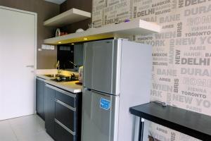 a kitchen with a refrigerator and a wall with words on it at Comfy Studio Apartment @ Skylounge Tamansari By Travelio in Tangerang