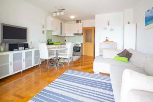 a living room with a white couch and a table at Apartman Adriatic Sea in Promajna +19 photos