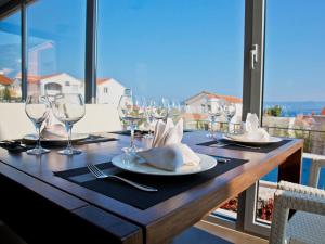 a wooden table with glasses and napkins on top of it at Villa Dalmatina - Adults Only Apart-Hotel in Bol