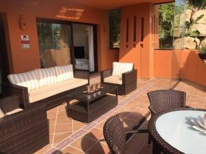 un patio con sofá, sillas y mesa en Beautiful apartment in Costa del Sol,300m from sea, en Estepona