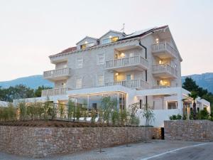 un gran edificio de apartamentos con una pared de piedra en Villa Dalmatina - Adults Only, en Bol