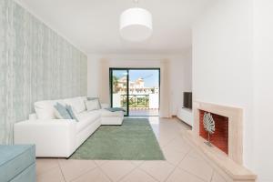 uma sala de estar com um sofá branco e uma lareira em Santa Eulalia BlueSea Apartment em Albufeira