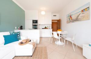 a white living room with a white couch and a table at Oura BlueSea Apartment in Albufeira