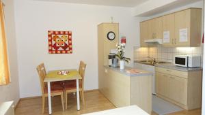 a kitchen with a table and a small kitchen with a microwave at Appartements Alpha-Graz in Graz