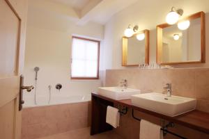 a bathroom with two sinks and a tub at Hotel Fahrnberger in Göstling an der Ybbs