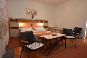um quarto com uma cama, uma mesa e cadeiras em Apartment Nadica em Punat