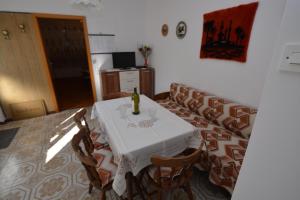 a dining room with a table and a couch at Apartment Nadica in Punat