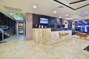 Four Sides Taksim Lion Hotel&Spa في إسطنبول: رجل يجلس في بار في بهو الفندق