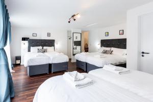 1 Schlafzimmer mit 3 Betten und weißer Bettwäsche in der Unterkunft Honeypot House in Newcastle upon Tyne