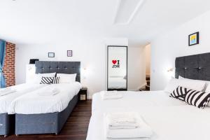 2 camas en una habitación con espejo en Honeypot House, en Newcastle