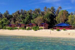 a group of bungalows on a beach with the water at Ira Bungalows Pulau Banyak in Alaban
