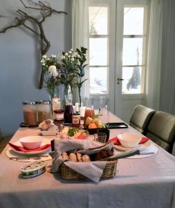 una mesa con un mantel blanco con comida. en Hunajakoto, en Jokioinen