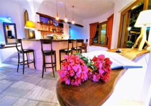 a living room with a table with flowers on it at Alkifron Hotel in Kala Nera