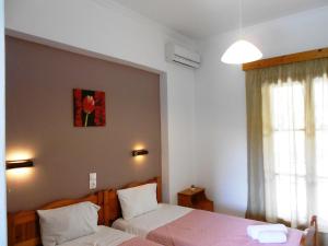 a bedroom with two beds and a window at Anemona Studios in Paleokastritsa
