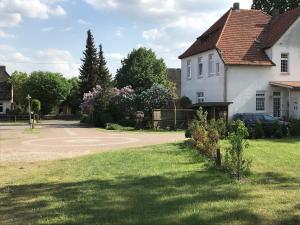 una casa blanca con un patio de césped y un camino de entrada en HeideZeit 3, en Neuenkirchen