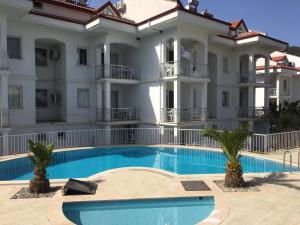 a large white building with a swimming pool at Infinity Olympia Apartments in Oludeniz