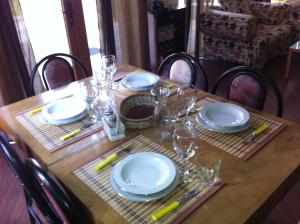 una mesa de madera con platos y vasos. en The Lake Villa, en Smolyan