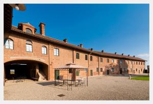 a large brick building with tables and chairs in front of it at Tenuta Isola in Langosco