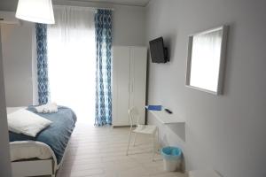 a bedroom with a bed and a desk and a window at Borgo 22 in Catania