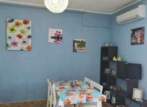 comedor con mesa y pared azul en La Casa Felice Appartamenti, en Chia