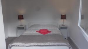 un letto con una camicia rossa sopra con due lampade di Casa do Chico a Vieira do Minho