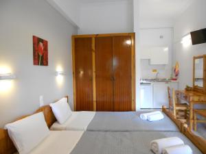a bedroom with a large bed and a kitchen at Anemona Studios in Paleokastritsa