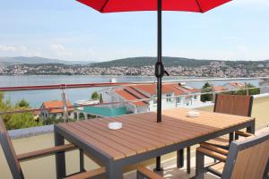 uma mesa de madeira com um guarda-chuva no topo de uma varanda em Villa Luna em Trogir