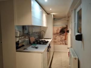 a kitchen with a stove and a counter top at Apartament Armia in Gdynia