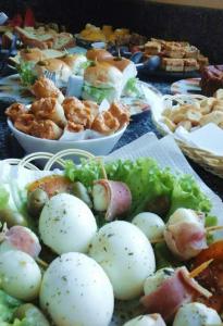 a table topped with plates of food with potatoes and salad at Pousada Do Sol in Parnaíba