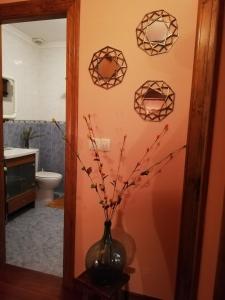 Un baño con un jarrón con flores. en Casa Rural Josefina, en Aliezo