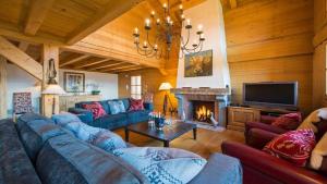 a living room with a blue couch and a fireplace at Chalet Dunmore in Verbier