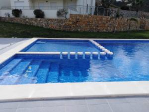 a large swimming pool with blue water and white coping at Monte Corona in Ador