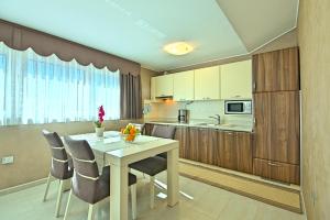 a kitchen with a table and chairs in a room at Apartments Riva-Interauto in Umag