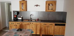 a kitchen with wooden cabinets and a sink at La Séranne, 7 places jardin piscine in Saint-Jean-de-Buèges