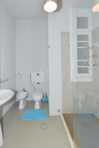 a white bathroom with a toilet and a sink at Oporto Rivoli Apartments in Porto