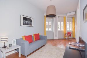 a living room with a blue couch and orange pillows at Oporto Rivoli Apartments in Porto